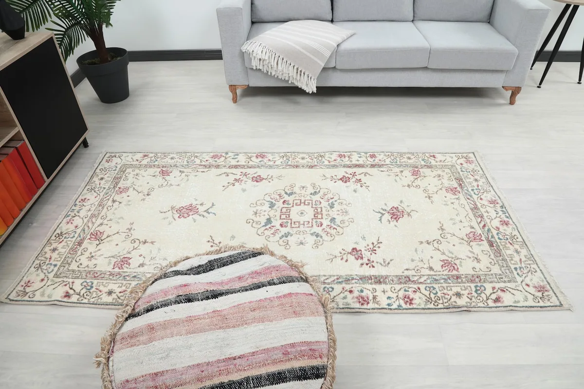 Full view of the rug in a room, showing its placement relative to a sofa and ottoman