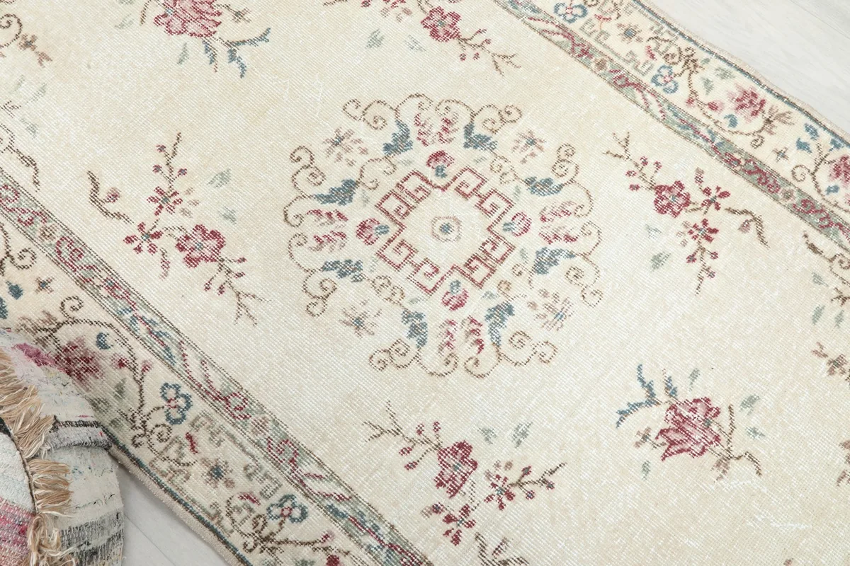 Close-up of the central medallion and surrounding floral patterns on the vintage rug
