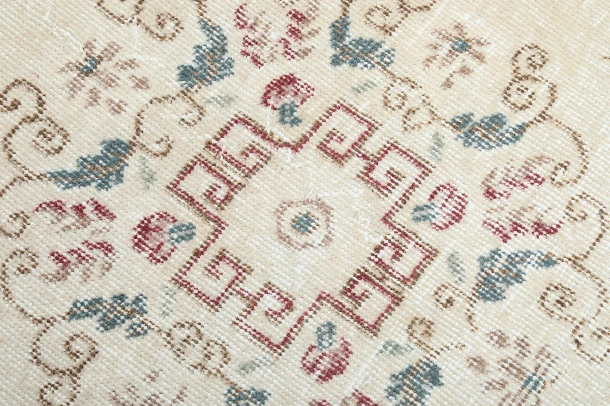 Macro detail of the central geometric medallion with pink and blue elements