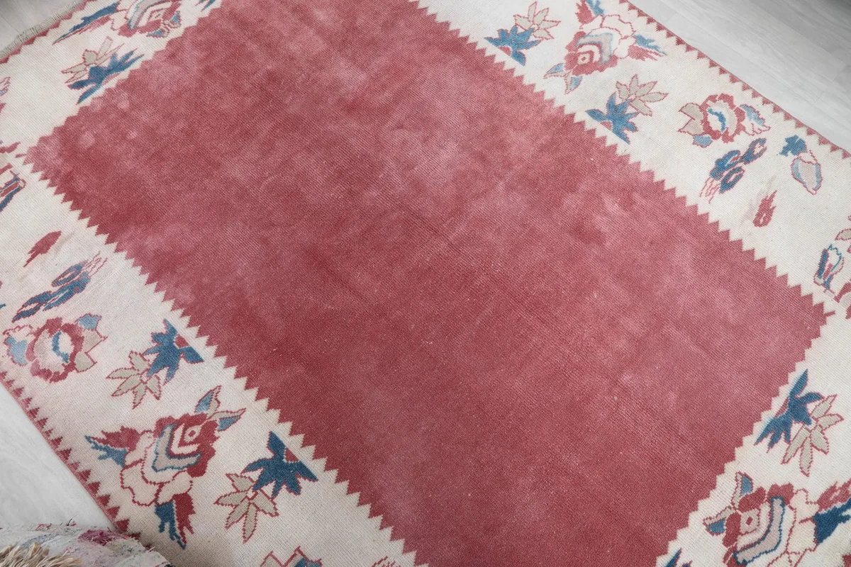 Diagonal view across the vintage rug highlighting the rose center