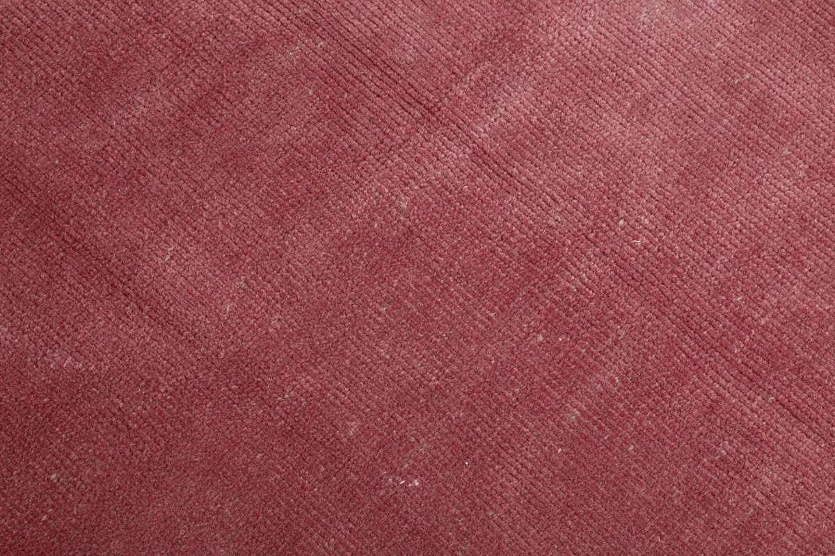Close-up of the low wool pile texture and subtle variations in the rose field