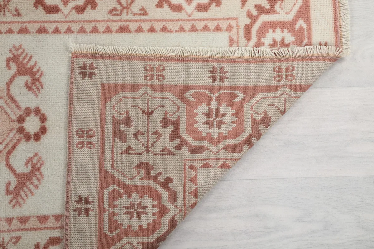 Underside of the rug, showing the intricate knotting and the cotton foundation beneath the wool pile.