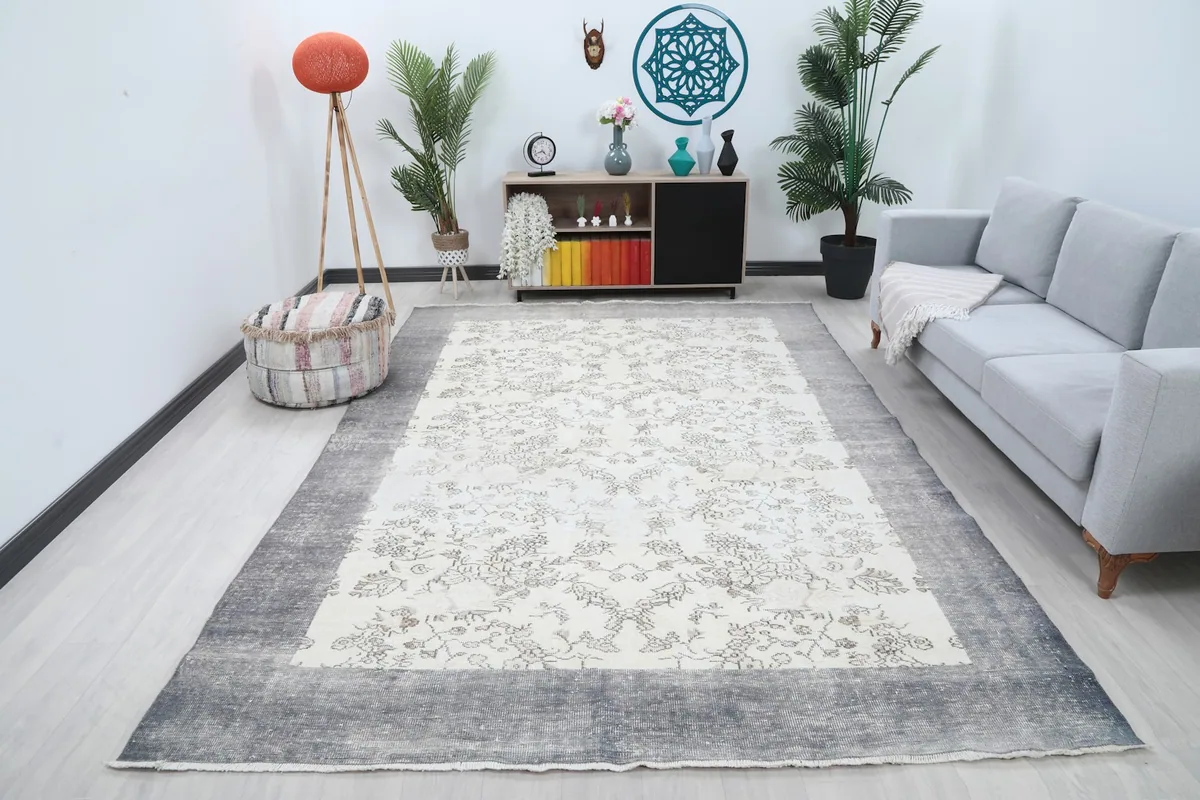 Ivory floral rug with gray border placed in a modern living room setting