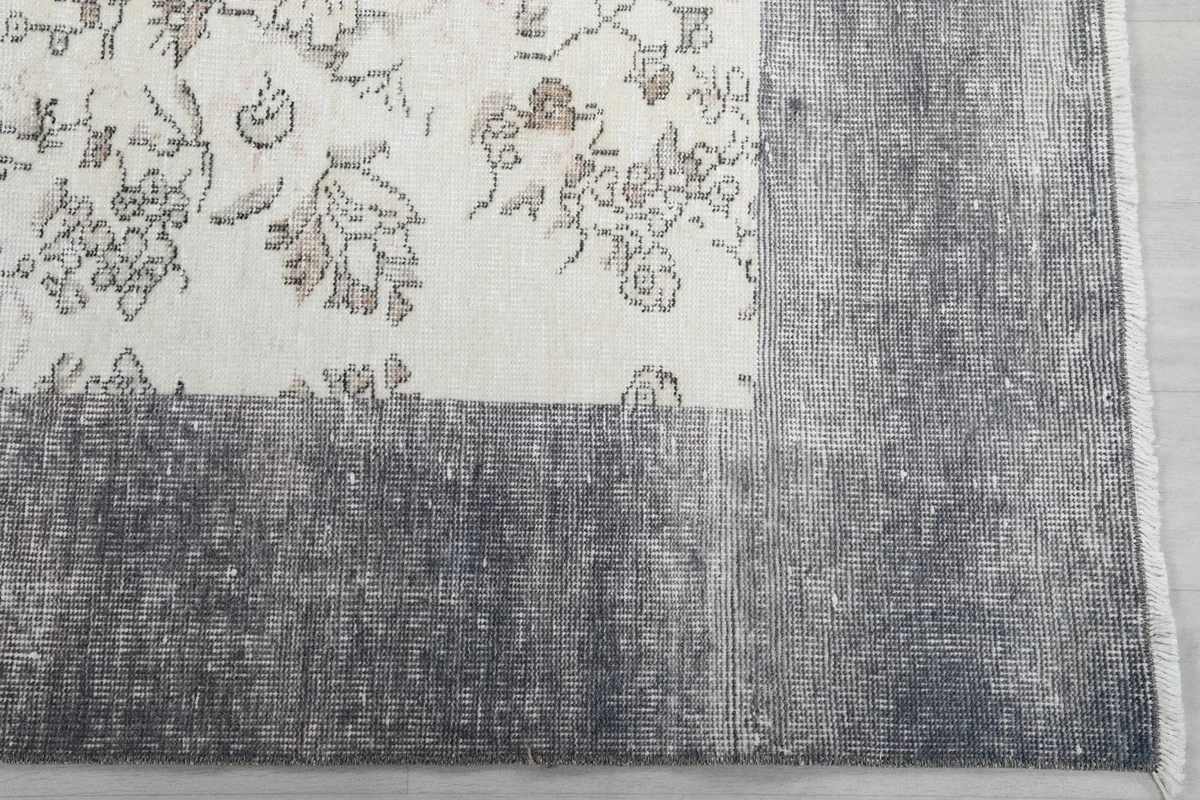 Detail of the gray border and corner of the vintage hand-knotted rug