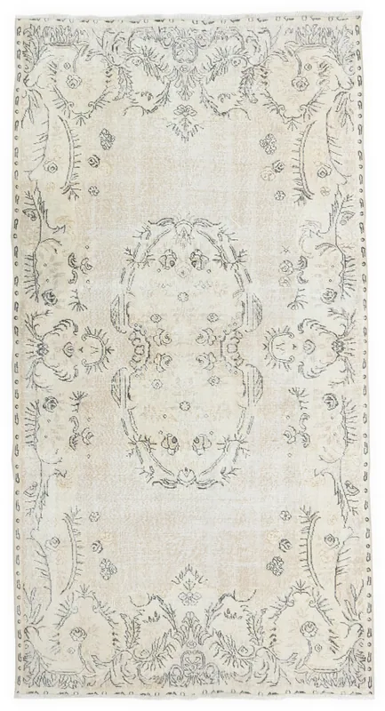 Full top view of the ivory and beige vintage Anatolian rug with charcoal floral medallion pattern