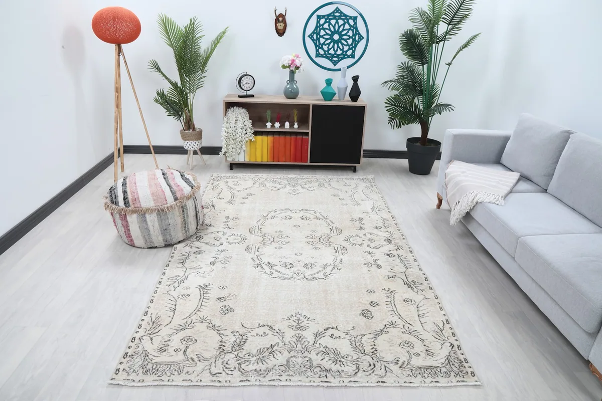 Vintage Anatolian rug displayed in a living room setting with a light gray couch and plants