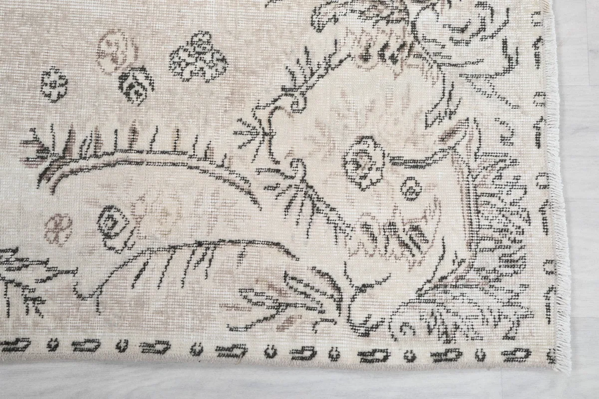 Detail of the rug's border and corner, showing the charcoal and gray motifs