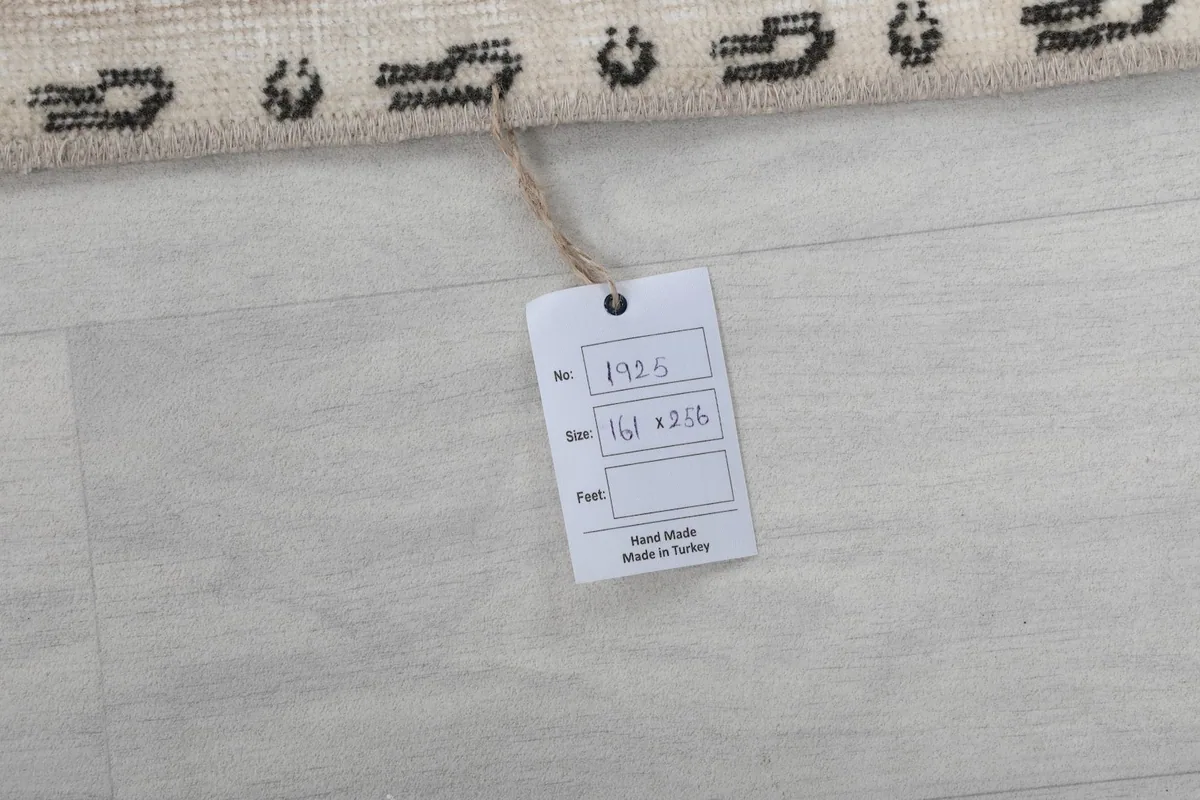 Close-up of the rug's reverse side with a tag indicating origin and size