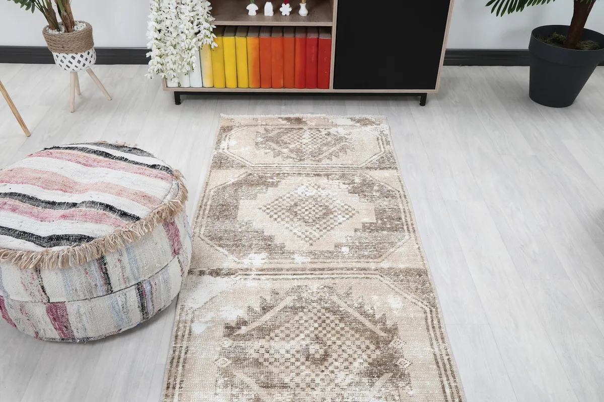 Runner rug in a room setting, viewed from a higher angle towards a bookcase