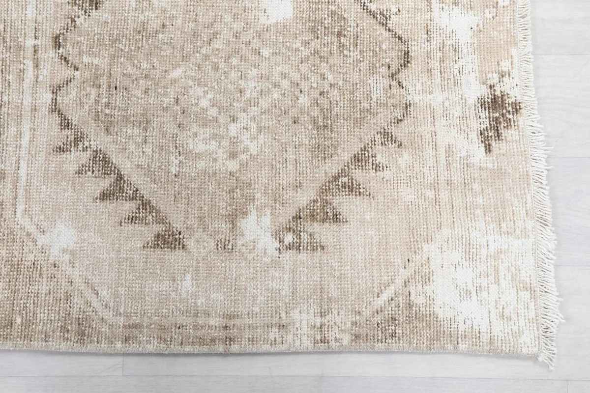 Detailed view of the rug's geometric pattern and fringe at one end