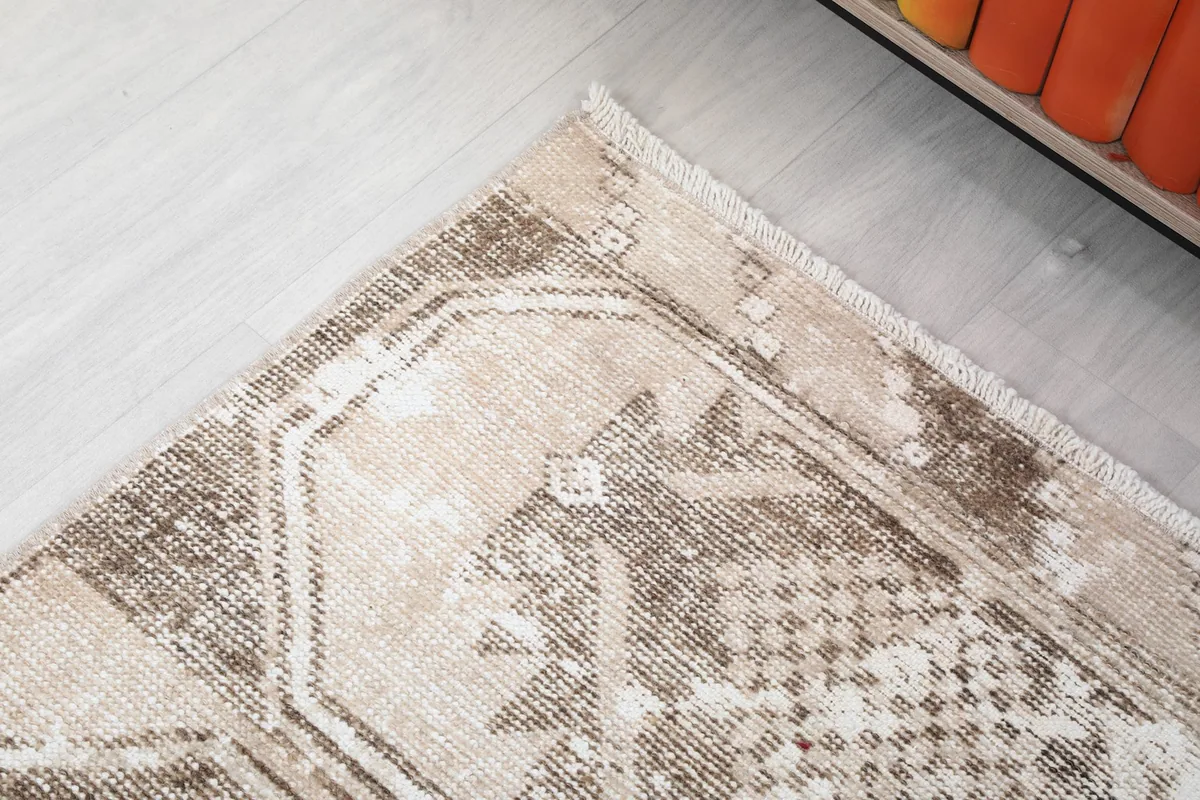 Corner detail of the rug, showing the border and subtle wear