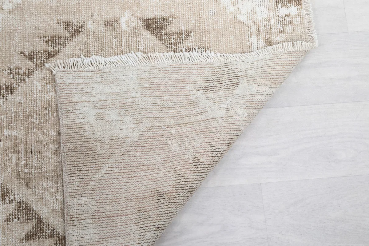 Another view of the rug's back, showing the hand-knotted construction and fringe