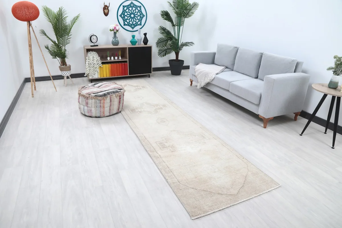 Overhead view of the ivory runner rug in a room, showing its length and placement between furniture.