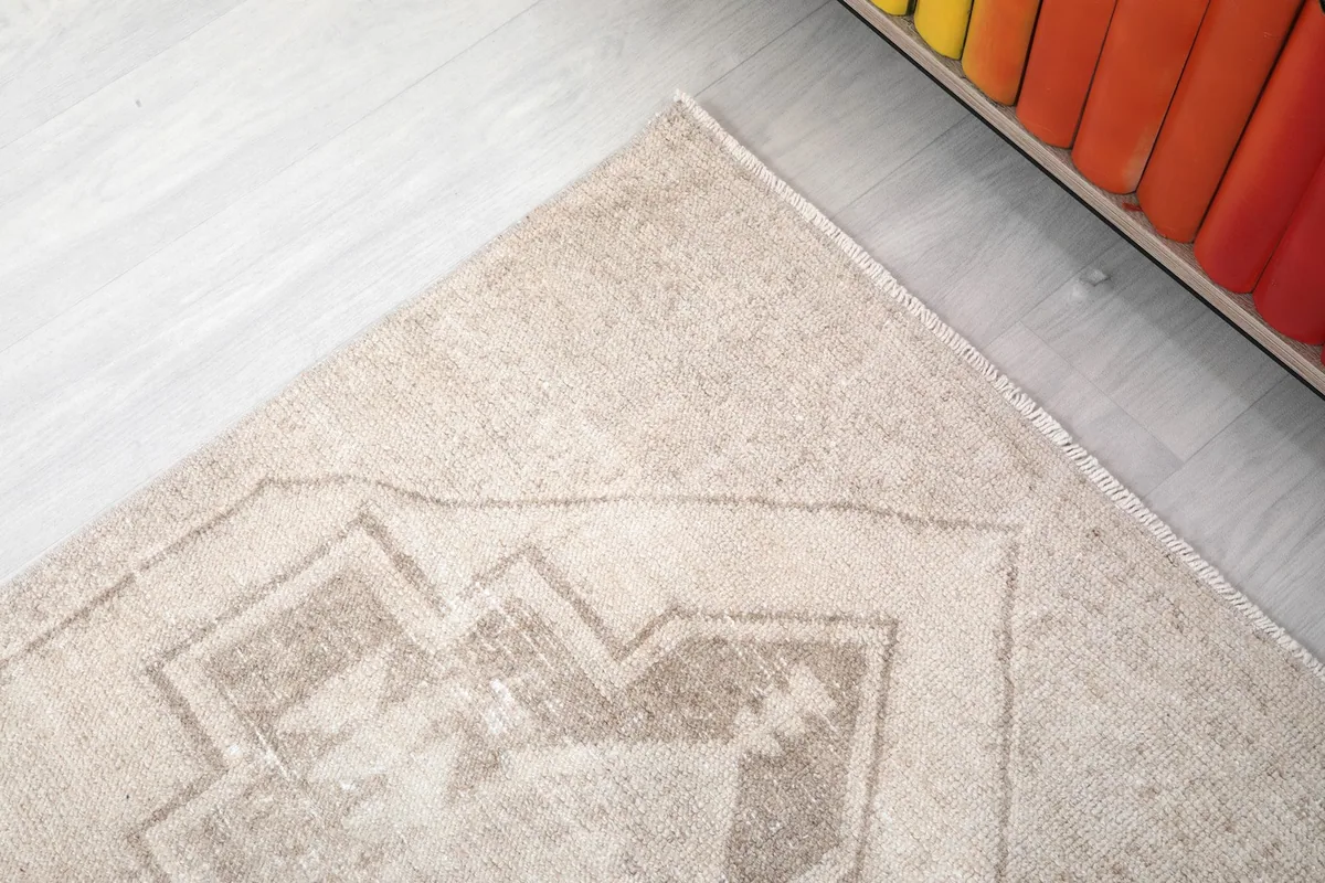 Close-up of the rug's edge and part of a tan geometric motif, showing the border design.