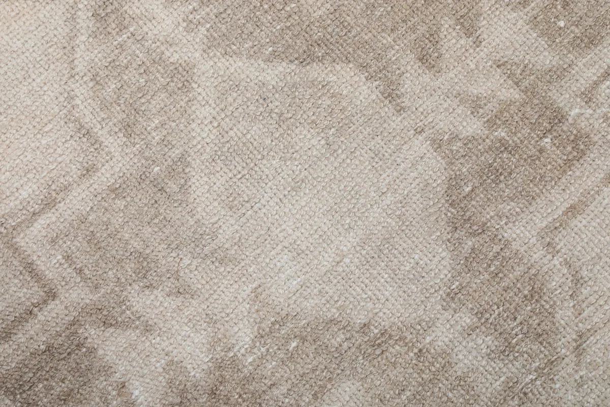 Extreme close-up of the hand-knotted wool pile, revealing the weave and gentle wear of the vintage rug.