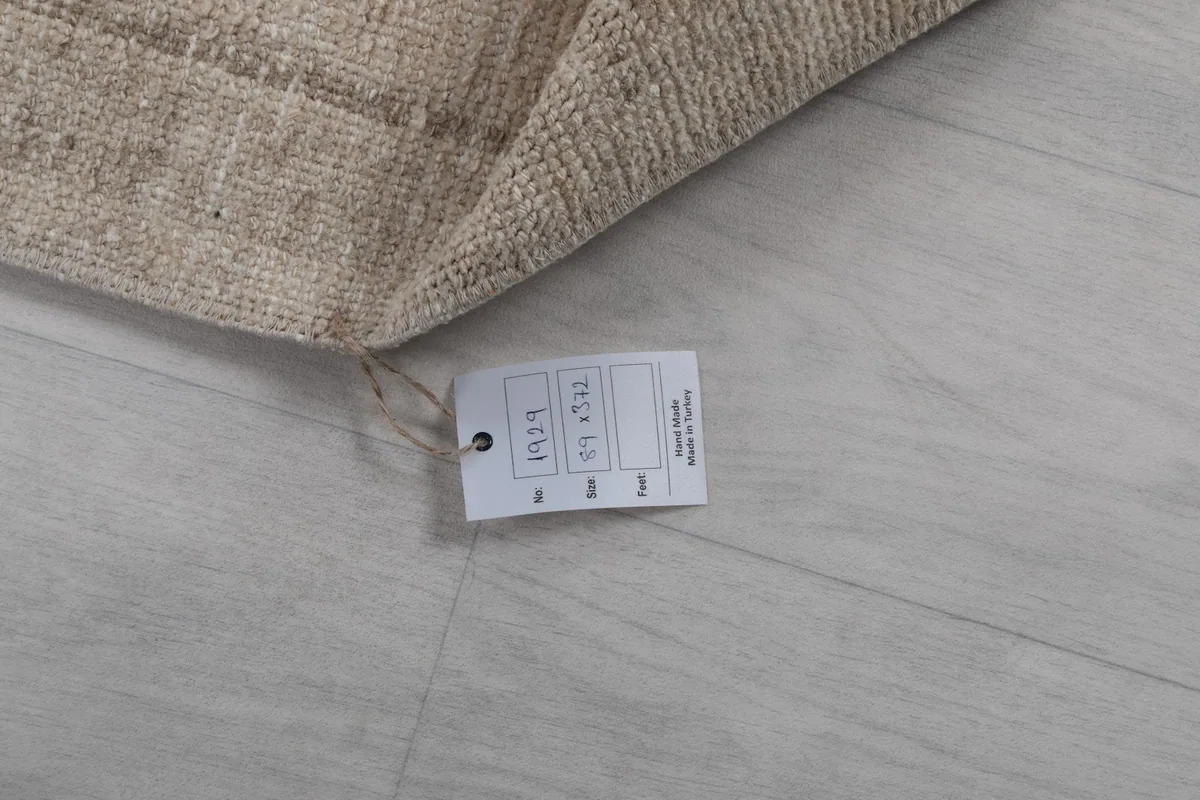 Close-up of the product tag attached to the rug, displaying size and material information.
