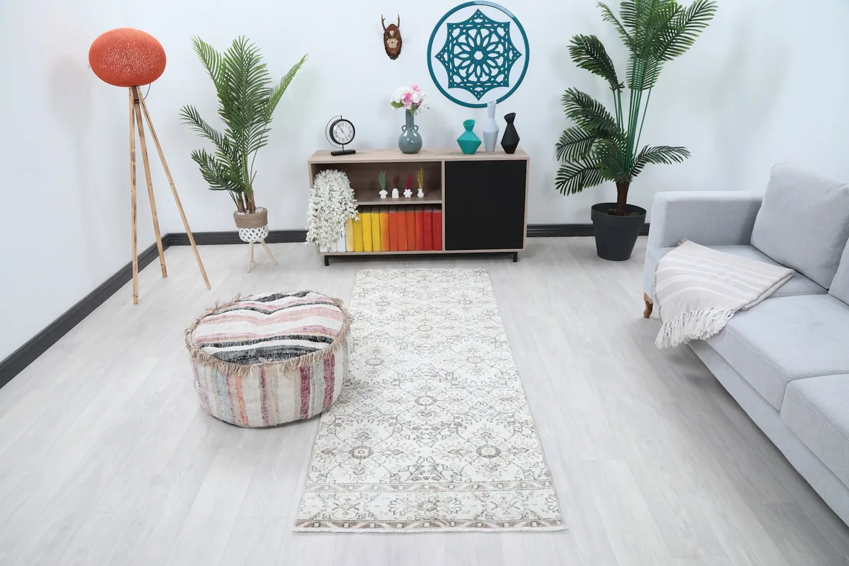 Ivory and tan runner rug displayed in a living room setting, showing its size and pattern relative to furniture.