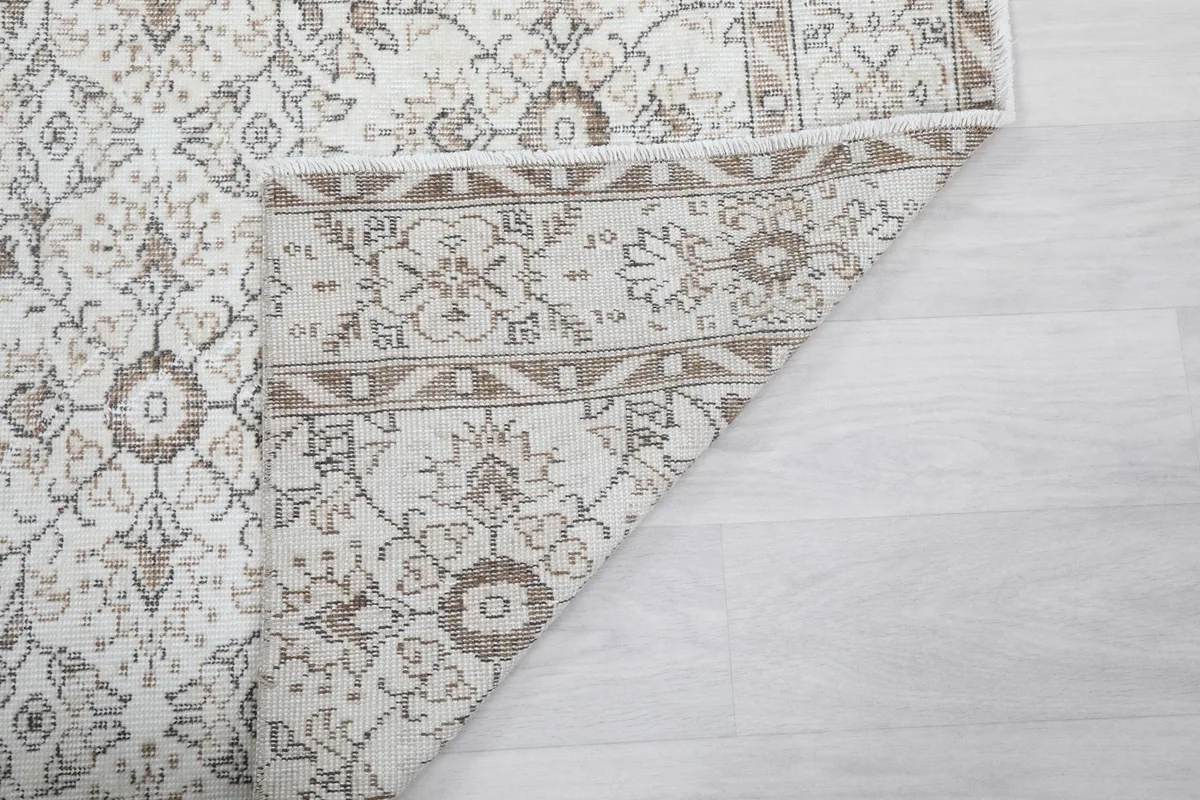 Close-up of the rug's reverse side and folded edge, showing the hand-knotted construction.