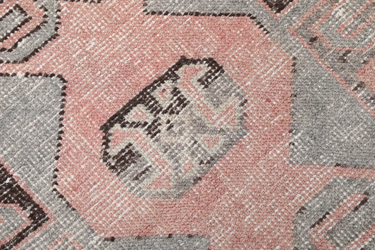 Close-up of a central geometric design element on the rose and gray runner