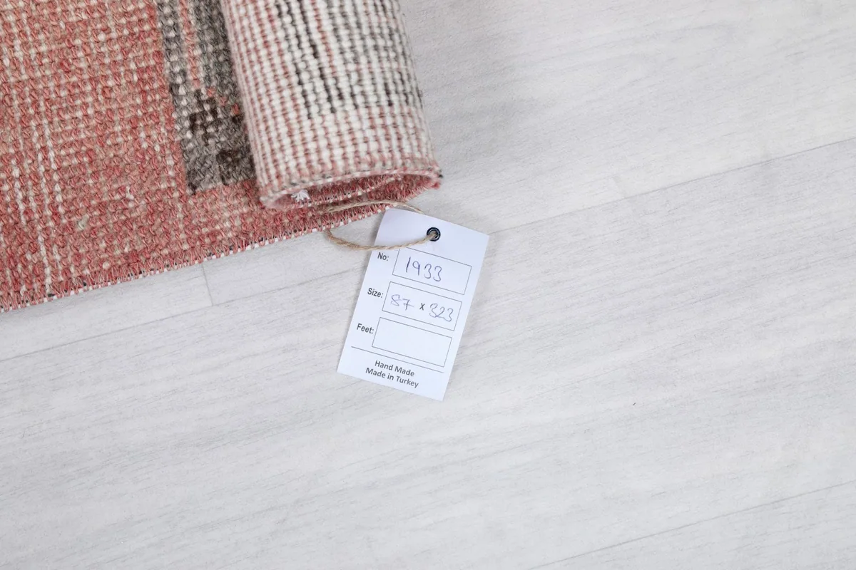 Rolled section of the runner rug with a product tag showing dimensions