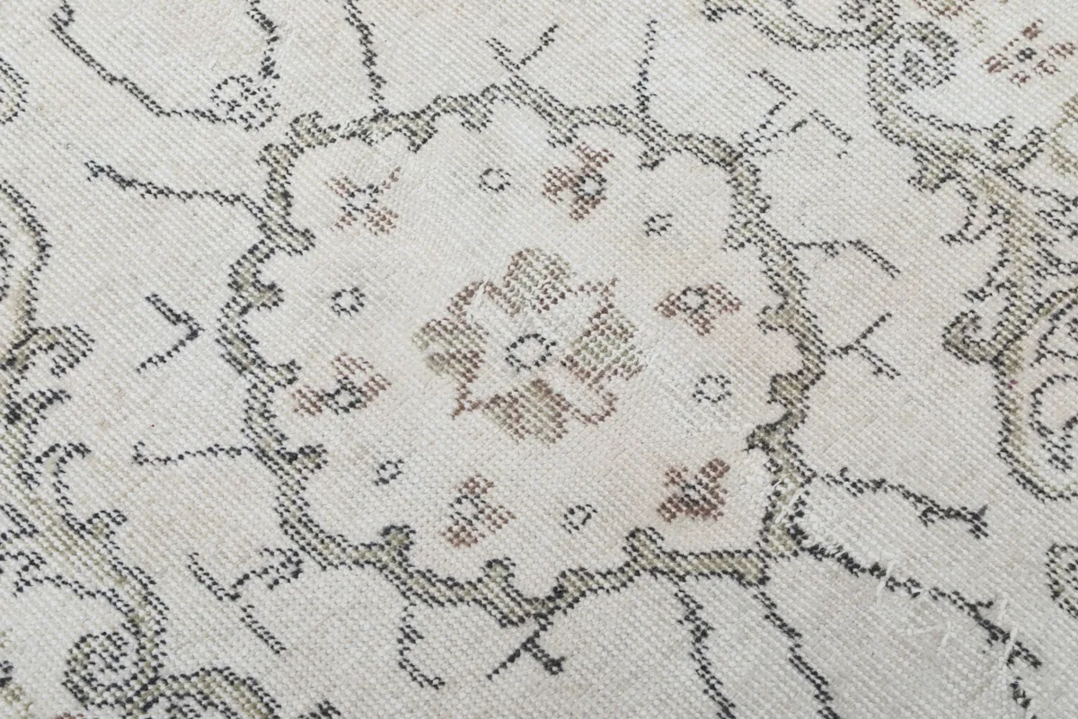 Intricate detail of the central medallion design, showing muted gray and beige tones