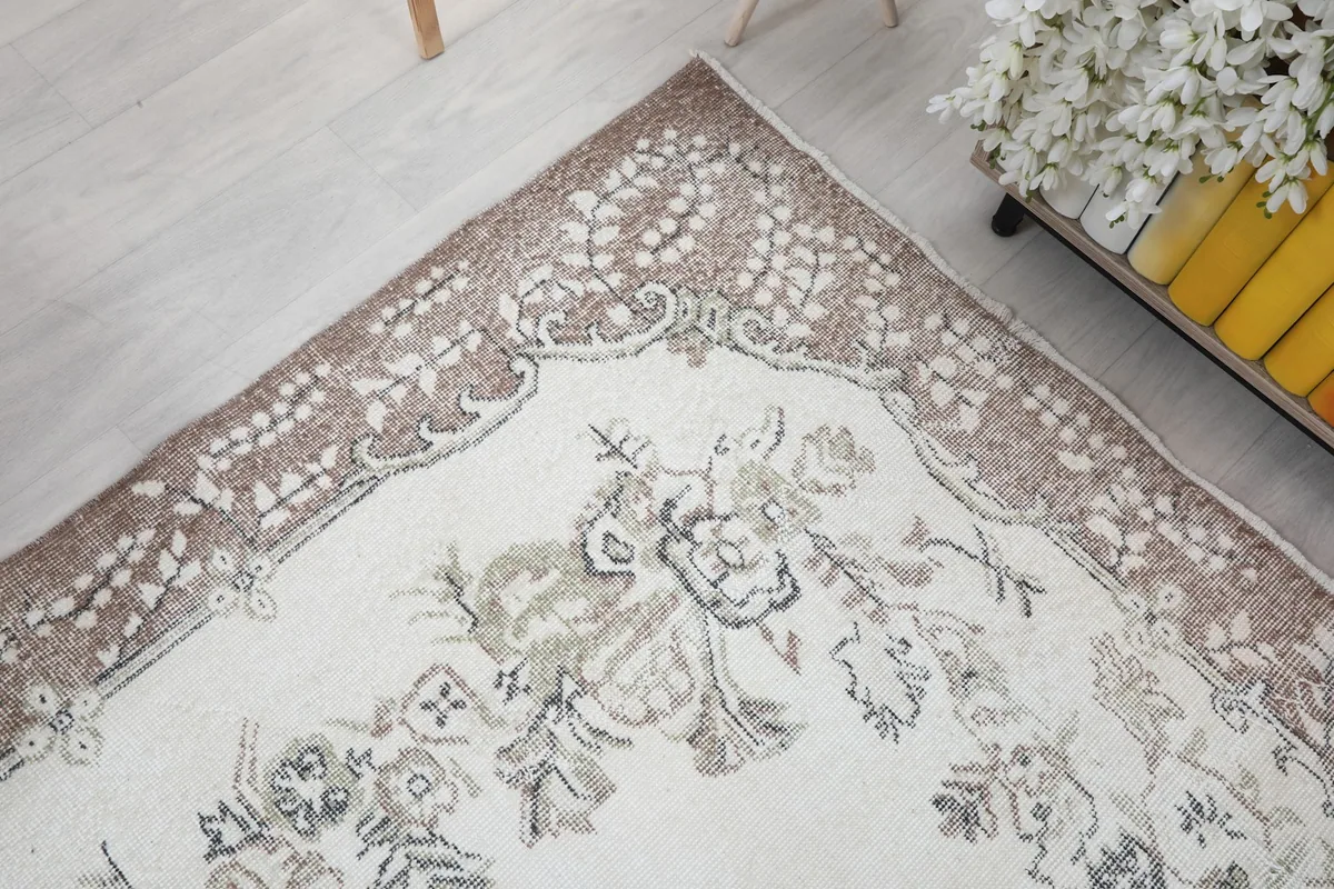 Corner detail of the rug, highlighting the transition from the cream field to the beige border
