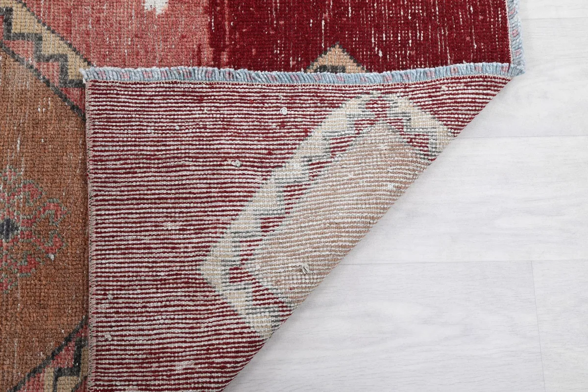 Close-up of the back of the rug, revealing the tight knotting and foundation colors