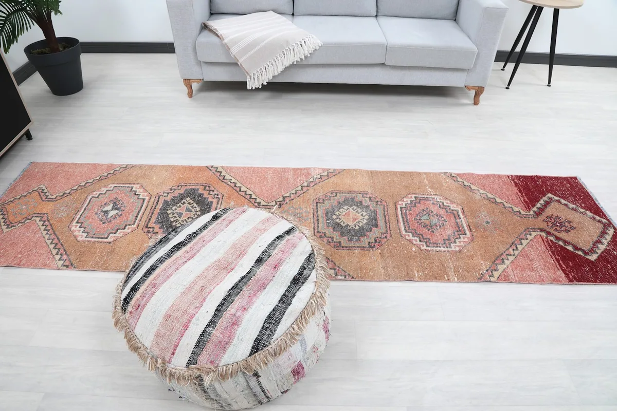 Overhead view of the entire runner rug laid out, with a pouf in the foreground