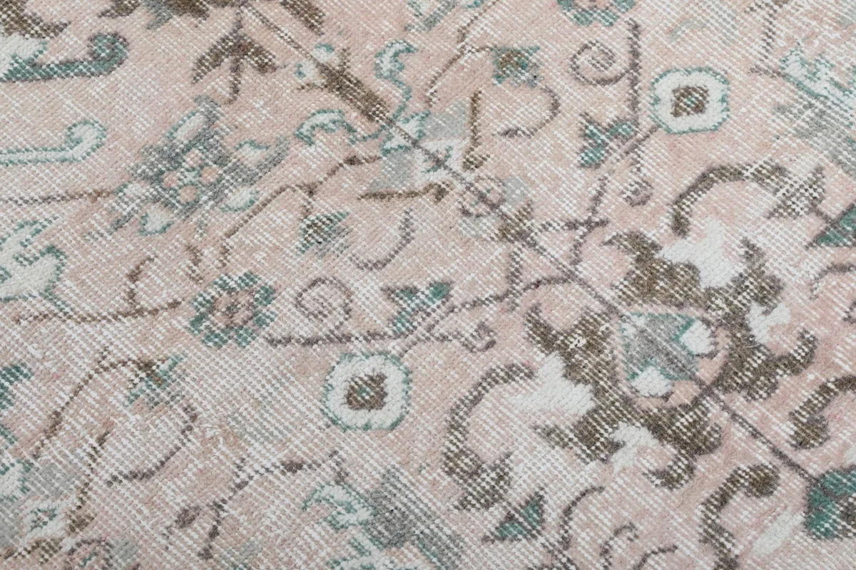 Close-up detail of the floral and geometric motifs in the rose field of the rug