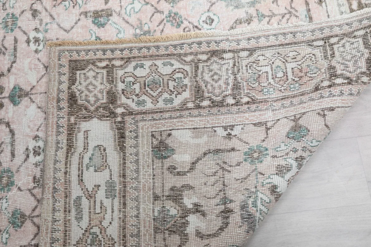 Close-up of the rug's corner, revealing the hand-knotted wool pile and foundation