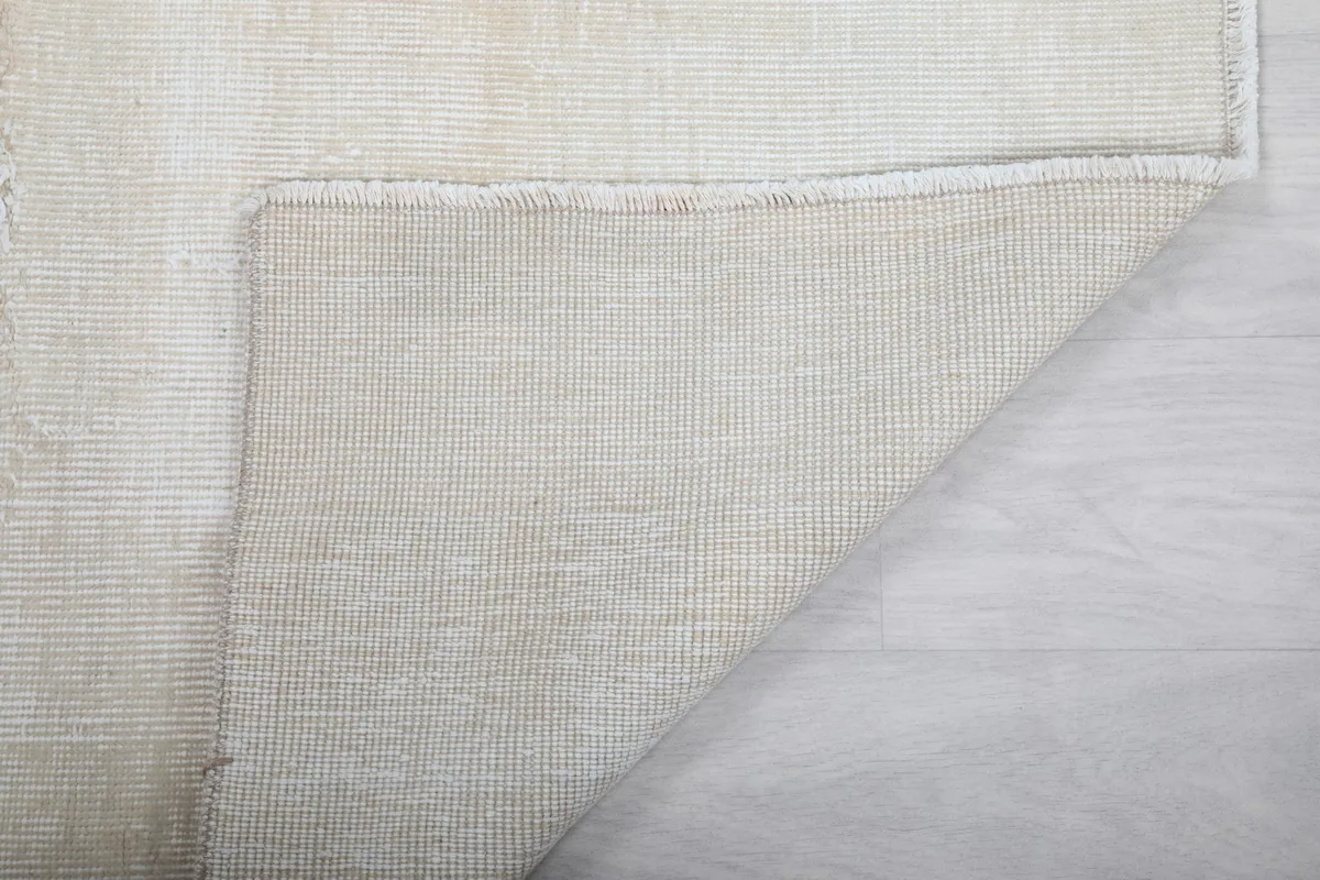 Close-up of the rug's reverse side, illustrating the durable cotton foundation and knotting.