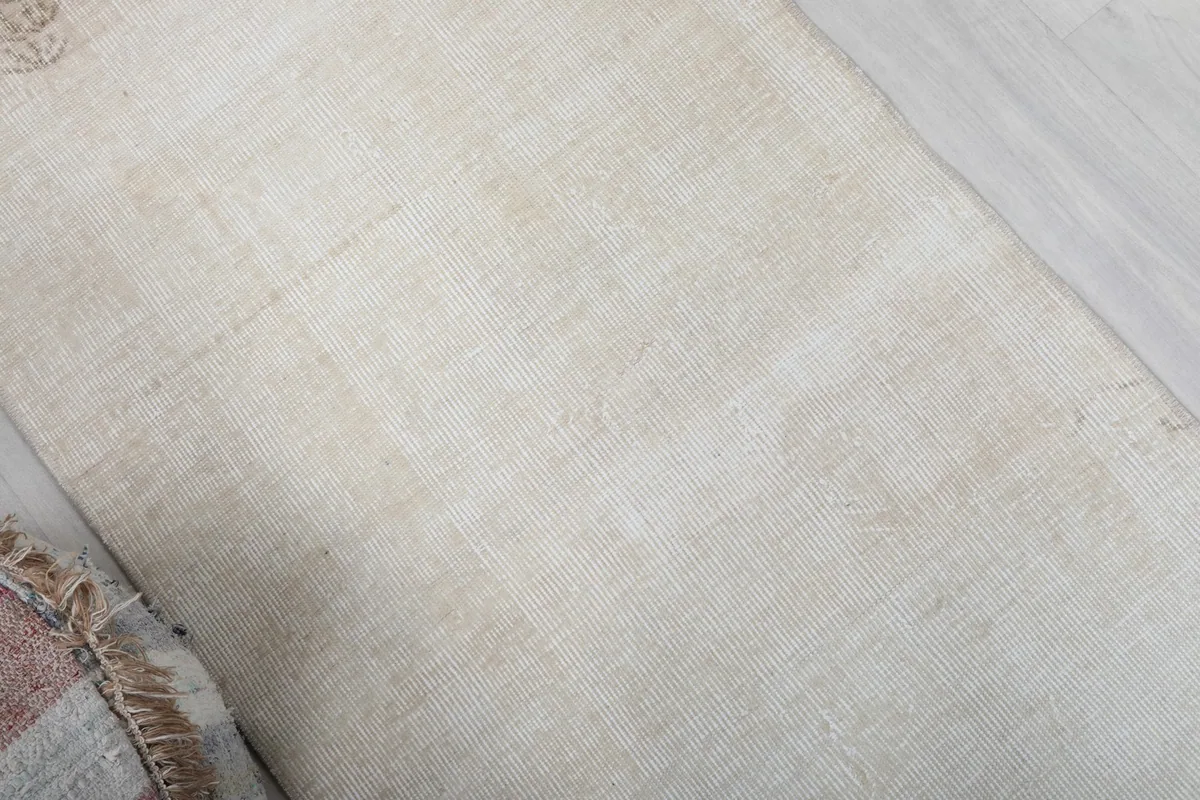 Overhead perspective showing the full field of the ivory rug with its gentle color shifts.