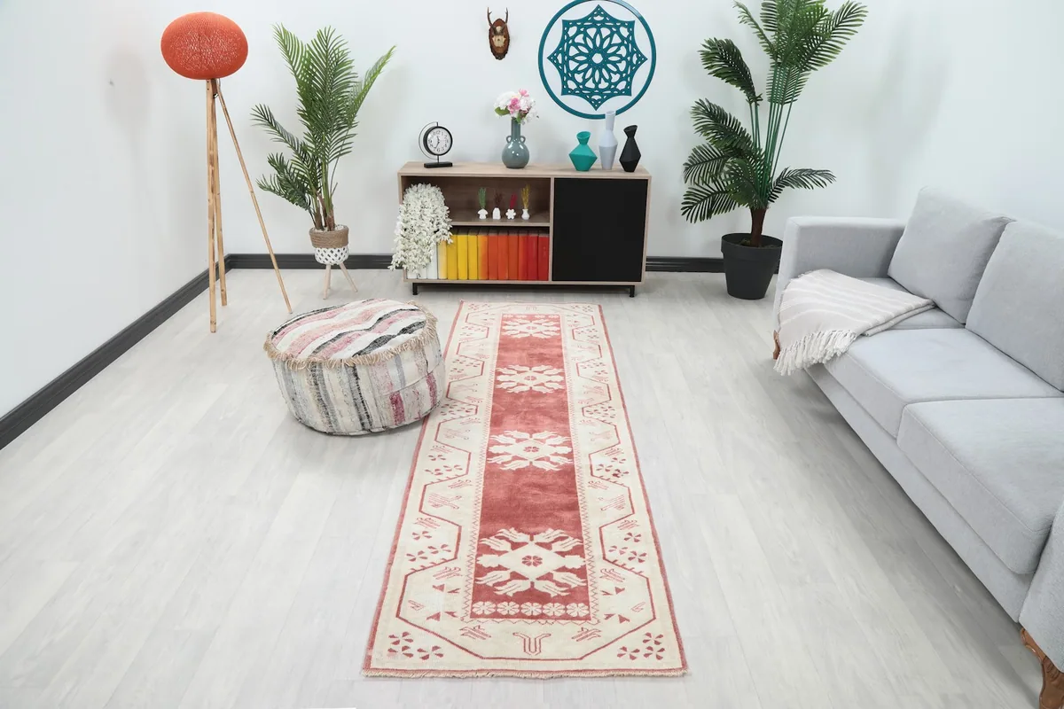 Rose and ivory runner rug in a modern living space with light flooring and gray couch