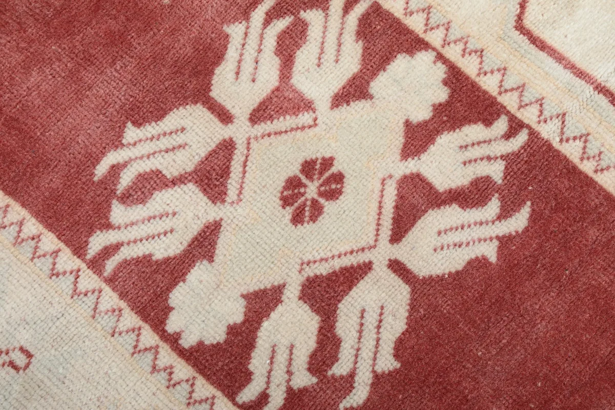 Close-up of the central ivory geometric motif on the rose field of the runner rug