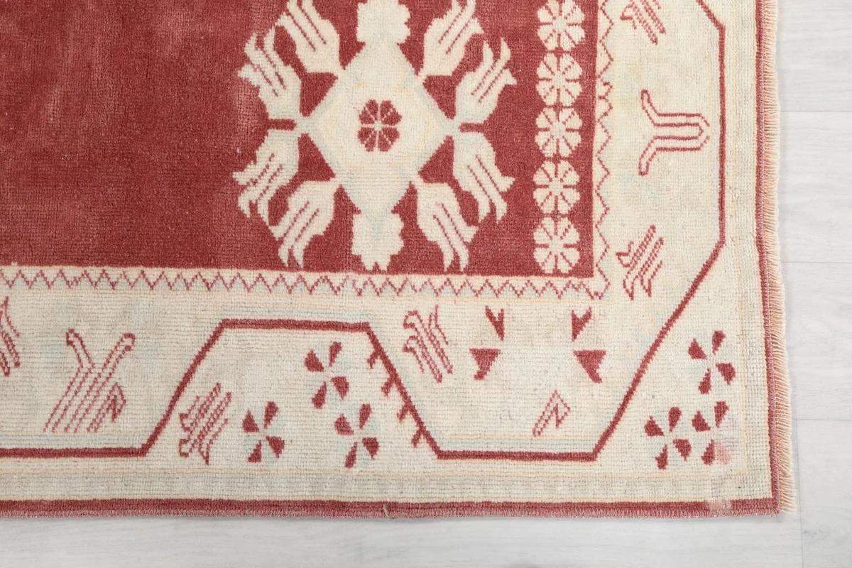 Detailed corner view of the ivory border with rose geometric motifs on the runner rug