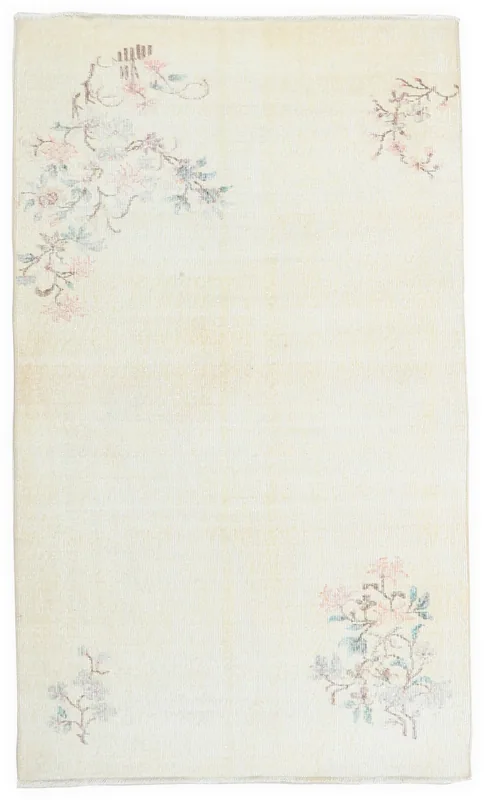 Top view of the 4x7 ivory vintage Anatolian rug with pink and green floral motifs on a white background