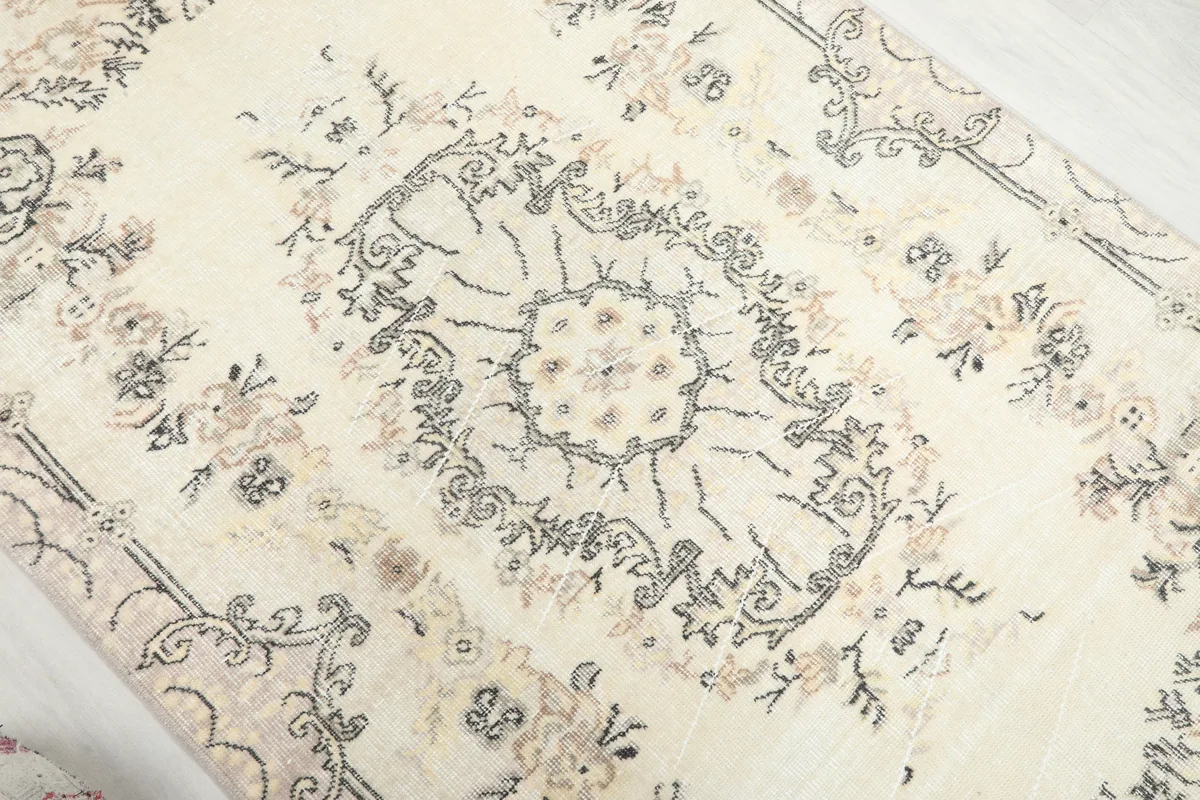 Detail view of the central medallion and surrounding floral patterns on the Cream Floral Medallion Anatolian Rug