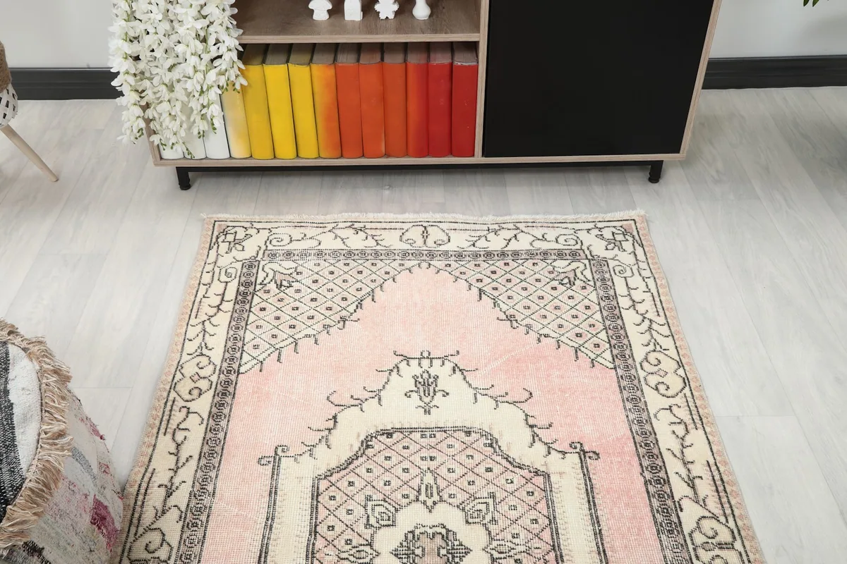 Overhead view focusing on the upper half of the pink and ivory Anatolian rug in a room