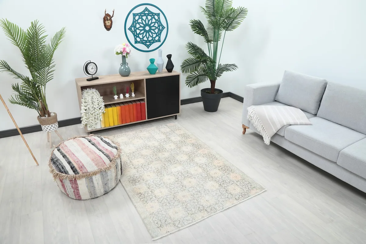 Overhead angle of the ivory and gray area rug in a room with modern furniture and plants.