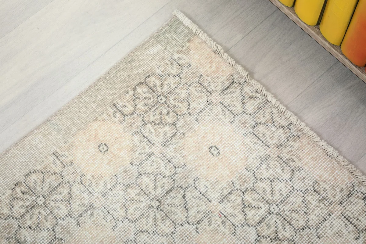 Corner detail of the rug, showing the fringe and the subtle color variations in the design.