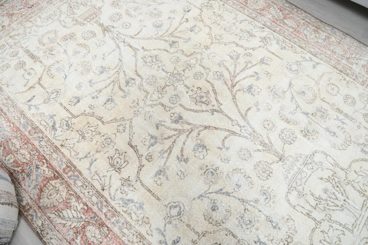 Close view of the vintage rug's ivory field showing light wear and patina