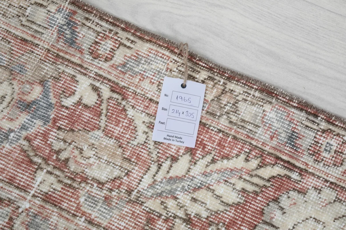 Close-up of the border showing the rug's tag with dimensions and origin