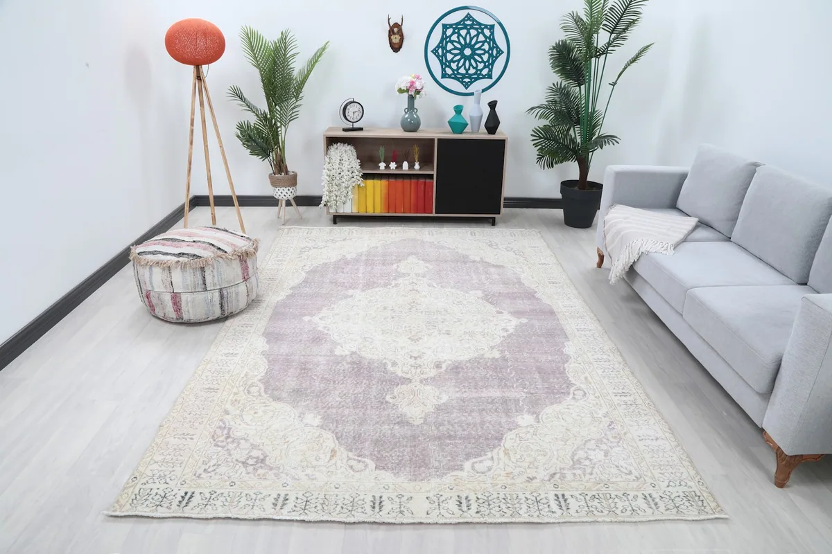 Vintage purple and cream rug in a modern living room setting with a light gray sofa