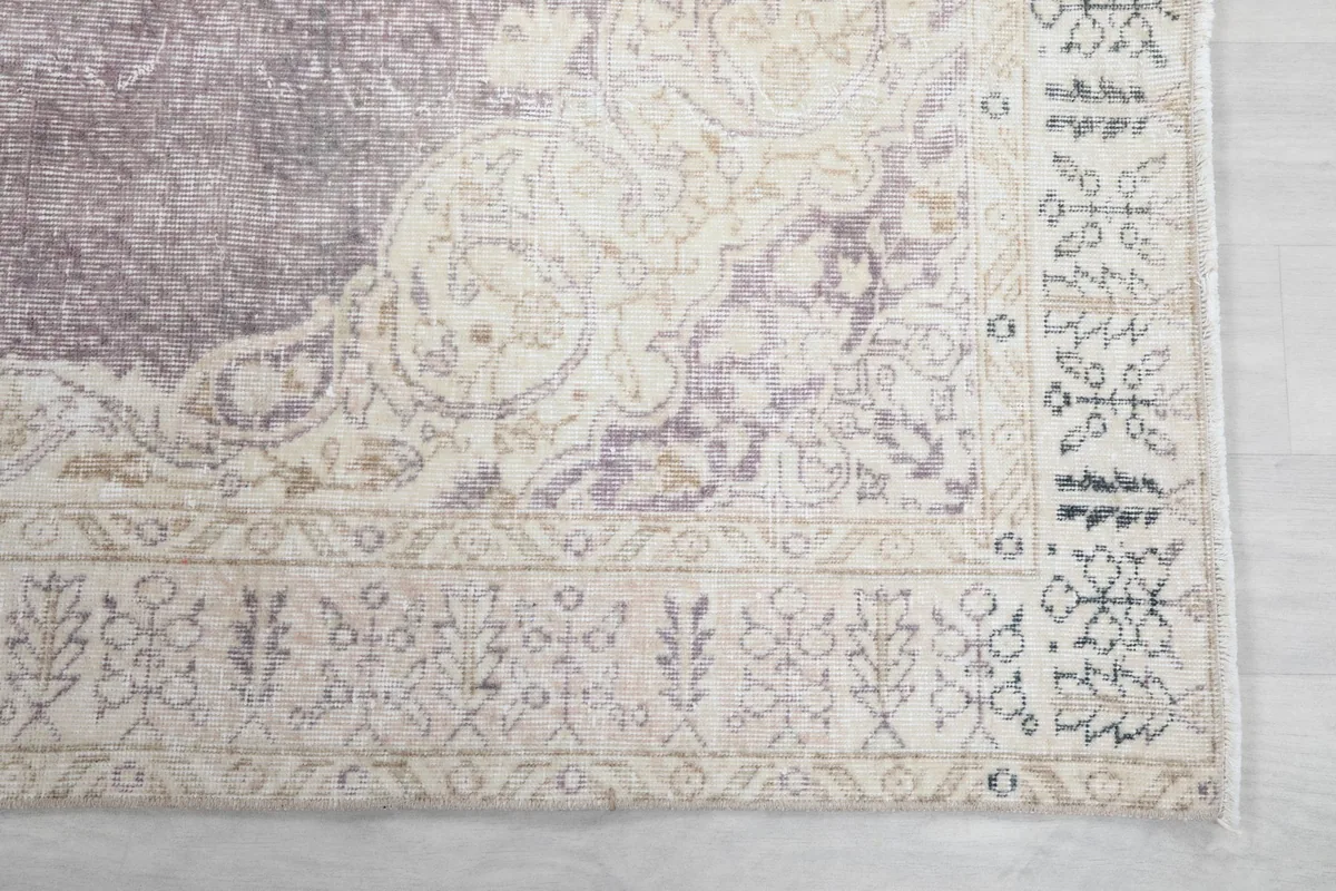 Detailed view of the cream border design with geometric motifs and the corner of the rug