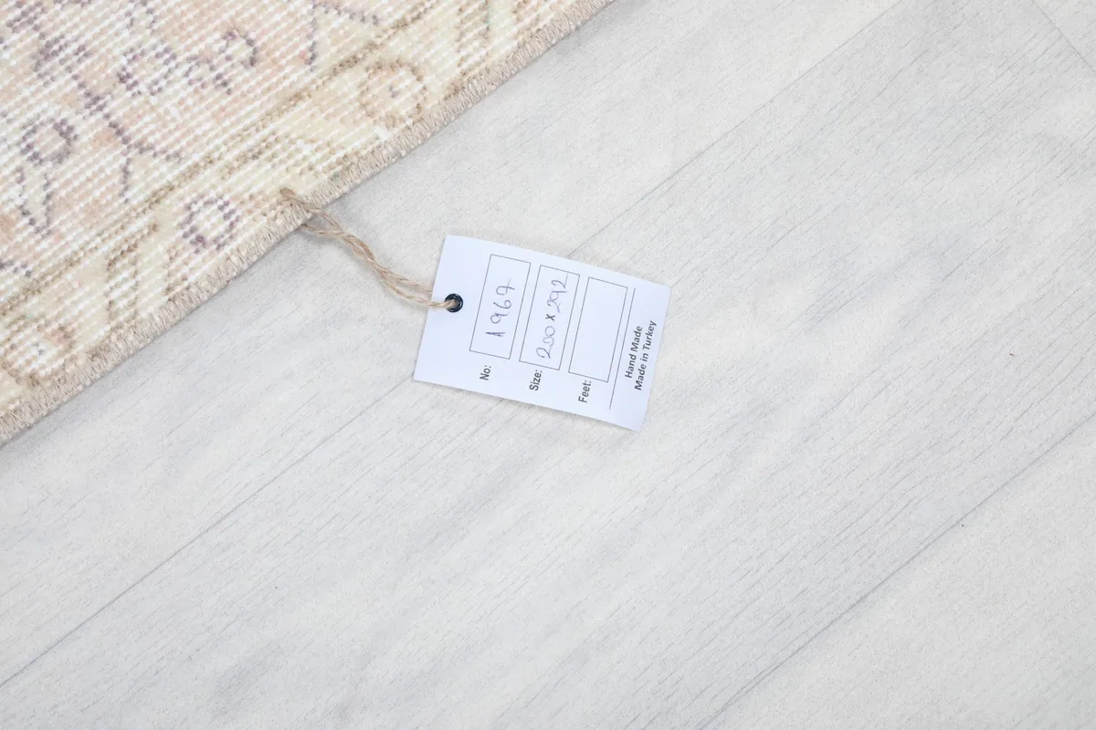 Product tag attached to the rug, indicating its hand-knotted origin and size