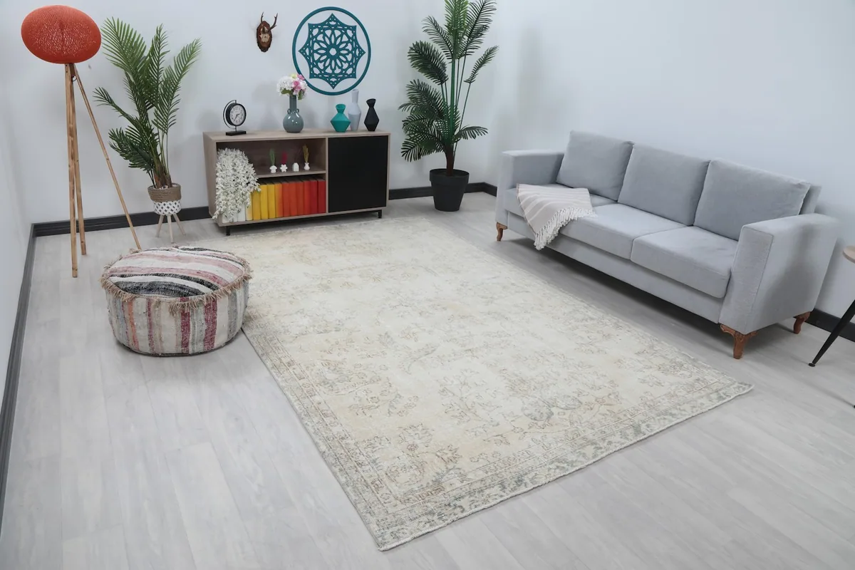 Wide shot of the cream Anatolian rug in a living space, showing its scale relative to furniture