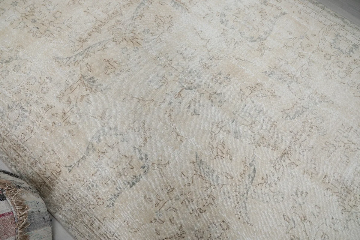 Detailed view of the rug's central field with intricate, softly visible floral and vine patterns