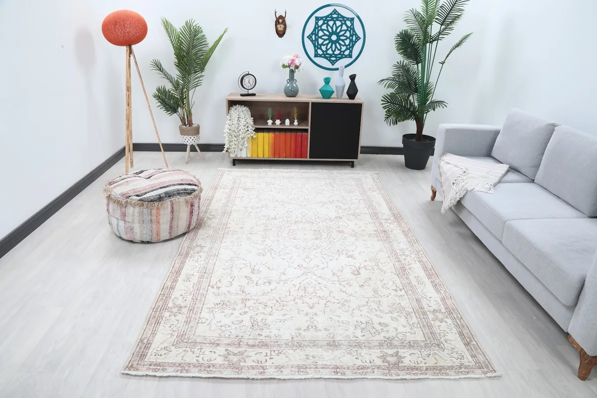 Ivory and rose vintage Anatolian rug displayed in a modern living room setting.