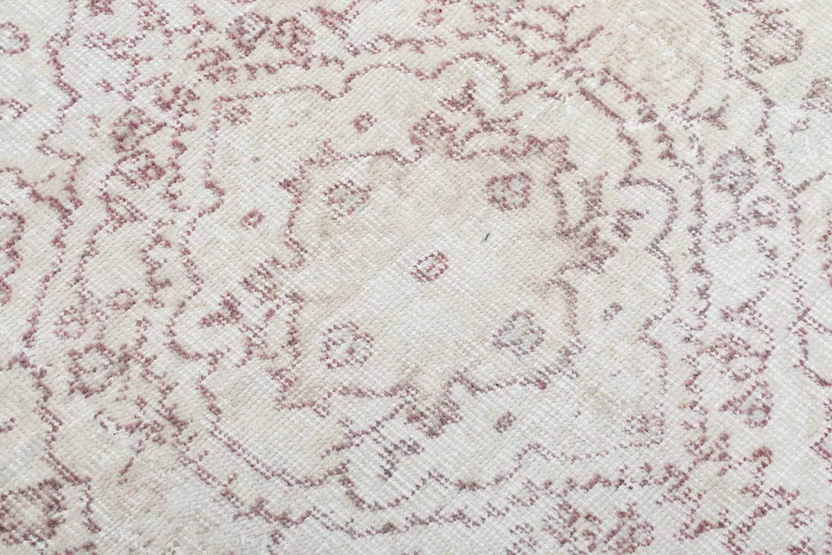 Texture and low pile of the hand-knotted wool, showing subtle color variations and wear.