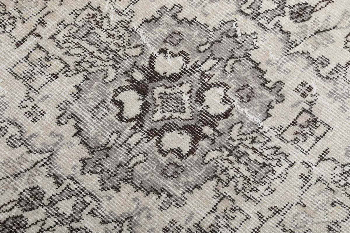 Close-up of the central medallion showing the hand-knotted wool pile and gray patterns